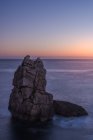 Pintoresco paisaje de rocas en el mar tranquilo y horizonte en el crepúsculo en la Costa Brava - foto de stock