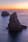 Картинні краєвиди скель у спокійному морі і горизонт у сутінках у Коста - Браві. — стокове фото