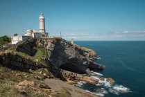 Scenic landscape of white lighthouse on cliff seashore of Costa Brava in sunny day — Stock Photo