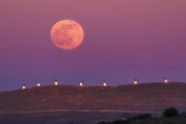 Paysage étonnant de pleine lune majestueuse sur la vallée avec des moulins à vent au coucher du soleil — Photo de stock