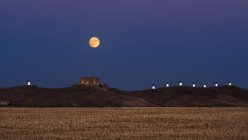 Dal basso pittoresco scenario della fortezza abbandonata sulla cima della montagna illuminata dalla luna piena di notte a Toledo — Foto stock