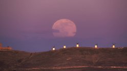 Дивовижні пейзажі величного повного Місяця над долиною з вітряними млинами на заході сонця — стокове фото