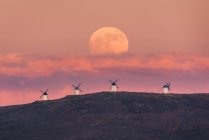 Дивовижні пейзажі величного повного Місяця над долиною з вітряними млинами на заході сонця — стокове фото