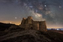 Paisagem surpreendente de palácio antigo abandonado na montanha sob céu estrelado colorido à noite — Fotografia de Stock