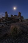 Снизу неузнаваемый турист исследует разрушенный средневековый замок под звездным небом с Млечным Путем ночью — стоковое фото