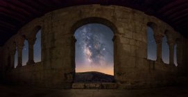 Fish eye view of Milky Way galaxy through arch entrance of old ruined castle at night — Stock Photo