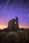 Malerische Landschaft der alten verlassenen zerstörten Burg unter buntem Sternenhimmel in der Nacht — Stockfoto