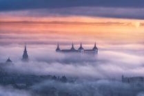 From above wonderful landscape of medieval castle built over city in misty colorful sunrise — Stock Photo