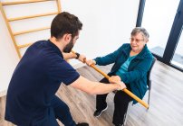 Fisioterapia con instructor personal en gimnasio - foto de stock