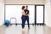 Sporty lady practicing resistance exercises with personal instructor — Stock Photo