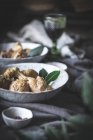 Des pilons de poulet cuits au-dessus avec bouillon dans un bol en céramique blanche décoré de verdure sur la table avec des épices et des boissons — Photo de stock
