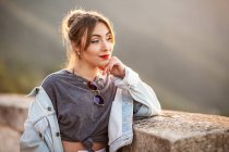 Joyful young woman in trendy casual outfit smiling and looking away on sunny day — Stock Photo