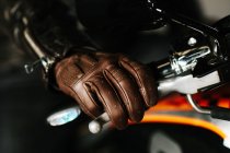 Homem elegante sentado em sua moto bonita dentro de uma garagem — Fotografia de Stock