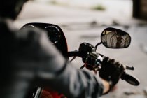 Homme élégant assis sur sa jolie moto à l'intérieur d'un garage — Photo de stock