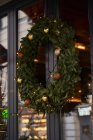 Фасад кафе з різнокольоровими прикрасами хвойних гілок і ялинки з гірляндами в денне світло — стокове фото