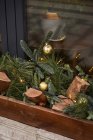 From above of decoration with firewood and coniferous branches with baubles on outside sill of cafe — Stock Photo