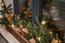 De cima da decoração com lenha e ramos coníferas com bugigangas na soleira externa do café — Fotografia de Stock