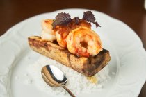 De arriba deliciosos camarones a la parrilla y arroz blanco servido en el plato sobre la mesa - foto de stock