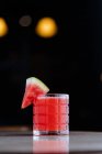 Холодно здоровый арбузный коктейль в стеклянной чашке, украшенный фруктами на отраженной поверхности — стоковое фото