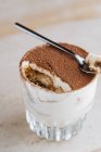 Dall'alto delizioso caffè tradizionale aromatizzato dessert tiramisù servito in tazza di vetro sul tavolo — Foto stock