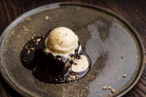 De cima delicioso bolo de chocolate brownie com sorvete de leite e nozes esmagadas no prato — Fotografia de Stock