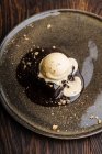 De cima delicioso bolo de chocolate brownie com sorvete de leite e nozes esmagadas no prato — Fotografia de Stock