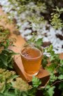 Von oben heißes gesundes Kräutergetränk mit Anisstern im Glasbecher auf Holzoberfläche im Garten — Stockfoto