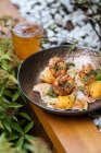 Dall'alto uova fritte fresche saporite con gamberetti coperti da erbe in pentola su tavolo di legno in giardino — Foto stock