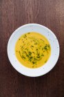 Зверху смачний апетитний овочевий вершковий суп у білій тарілці за столом у кафе — стокове фото