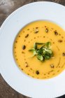 Зверху смачний апетитний овочевий вершковий суп у білій тарілці за столом у кафе — стокове фото