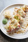 Frisches, schmackhaftes Sushi mit Gemüse auf weißem Teller auf dem Tisch — Stockfoto
