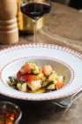 De cima a salada vegetal fresca suculenta da cenoura de couve-flor de tomate com verde na chapa branca ornamental na mesa redonda no restaurante — Fotografia de Stock