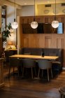 Bouteille sombre sur jaune capable entouré de chaises dans l'intérieur élégant du restaurant élégant avec une lumière chaude de la lampe ronde de mode — Photo de stock