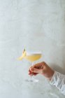 Pessoa irreconhecível cultivada segurando coquetel apetitoso fresco em vidro festivamente decorado com clothespin — Fotografia de Stock