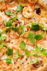 Зверху соковита запечена піца, яку подають з сиром, креветками та листям зеленого салату — стокове фото