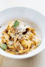 Dall'alto di piatto saporito con pasta larga cosparsa di formaggio e decorata con menta fresca in ristorante — Foto stock