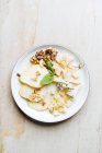 From above of square pieces of cheese with skewers decorated with fresh mint and slices of pear with walnut in restaurant — Stock Photo