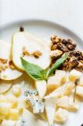 Зверху квадратних шматків сиру з шампурами, прикрашеними свіжою м'ятою і скибочками груші з горіхом в ресторані — стокове фото