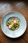 Вид на витаминный салат с кусочками огурца из помидоров черри и филе курицы на стильной тарелке в ресторане — стоковое фото