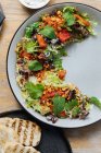 Vista dall'alto di gustosa insalata con polpo bollito pomodori secchi elegante decorato con verde su metà piatto e servito con pane arrosto — Foto stock