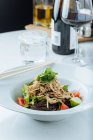 Von oben frischer Salat aus Tomaten, Limetten und Salat, serviert mit Fleischstücken und Petersilie im Restaurant — Stockfoto