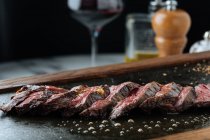 Vue de dessus des tranches moyennes rares steak sur la table avec fourchette et couteau au restaurant — Photo de stock