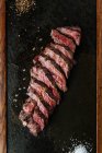 Vista superior de bife de fatias raras médio na mesa com garfo e faca no restaurante — Fotografia de Stock
