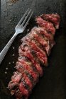 Draufsicht auf mittelseltene Scheiben Steak auf Tisch mit Gabel und Messer im Restaurant — Stockfoto