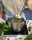Анонімний жіночий шеф-кухар починає готувати пельмені з барвистим тістом — стокове фото