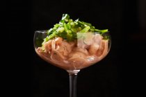 Crevettes frites avec sauce rouge et herbes vertes dans un verre aigre isolé sur fond noir — Photo de stock