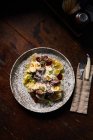 Vista dall'alto di carne bollita e uova di quaglia con erbe e verdure cosparse di formaggio grattugiato in un piatto elegante con stoviglie — Foto stock