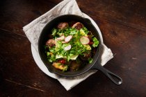 Жареные фрикадельки и салат в кастрюле — стоковое фото