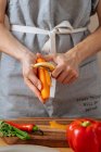 Persona anónima rebanando zanahoria para ensalada - foto de stock