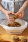 Mulher de colheita fazendo deliciosas costeletas veganas saudáveis feitas de lentilha e abobrinha na mesa de madeira com tigela branca — Fotografia de Stock